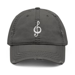 May include: A dark gray distressed baseball cap with a white treble clef embroidered on the front.