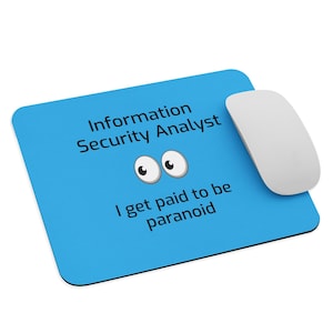 May include: A blue mousepad with the text "Information Security Analyst" and "I get paid to be paranoid" in black. The mousepad has cartoon eyes and a white mouse.