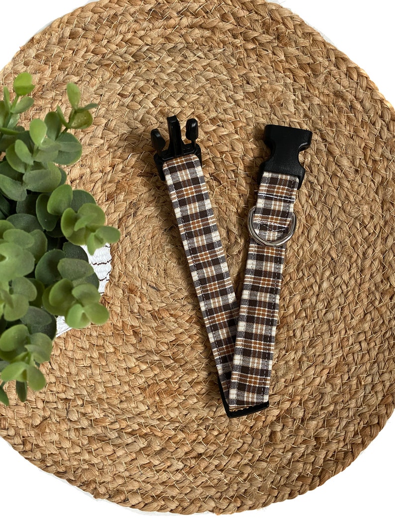 May include: A brown and white plaid dog collar with black plastic buckles.