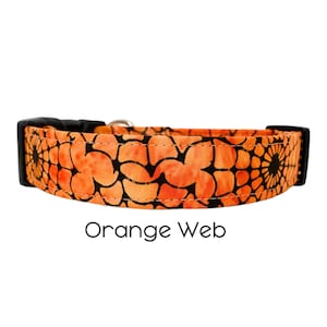 Może przedstawiać: Pomarańczowy i czarny obroża dla psa z wzorem. Wzór jest kwiatowy z wyglądem przypominającym sieć. Tekst "Orange Web" znajduje się pod obrożą.
