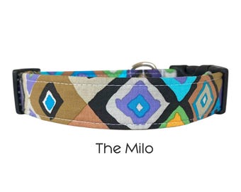 Op de afbeelding: Een hondenriem met een geometrisch patroon in bruin, blauw, paars en zwart. De halsband heeft een zwarte gesp en een metalen D-ring. De tekst "The Milo" staat eronder.