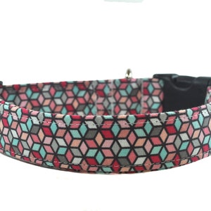 Op de afbeelding: Een hondenhalsband met een geometrisch patroon in roze, blauw en grijs met een zwarte plastic gesp.