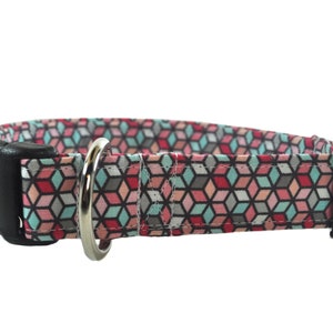 Op de afbeelding: Een hondenhalsband met een geometrisch patroon in roze, blauw en grijs met een zwarte gesp en een zilveren D-ring.