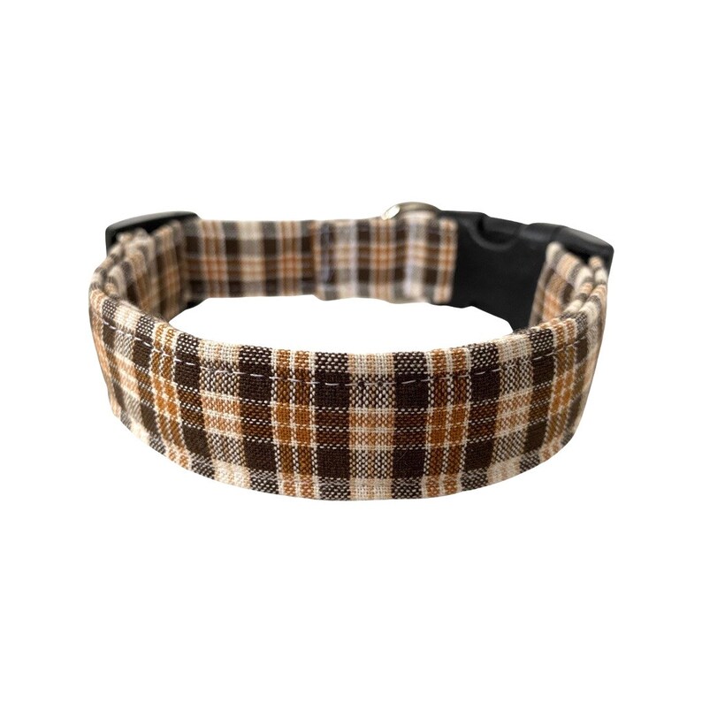 May include: A brown and tan plaid dog collar with a black plastic buckle.