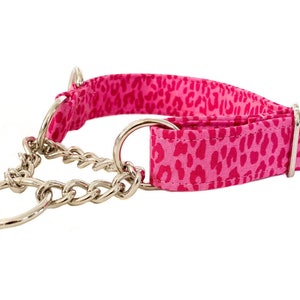 Puede incluir: Collar de perro de estampado de leopardo rosa y blanco con una cadena plateada.