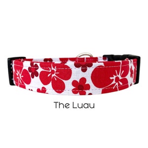 May include: A white dog collar with a red floral pattern. The collar has black hardware and the text "The Luau" is printed below the collar.