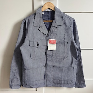 Puede incluir: Chaqueta de trabajo a rayas azules y blancas con dos bolsillos en el pecho y dos bolsillos inferiores. La chaqueta tiene cierre de botones y cuello. Una etiqueta con la marca "Marsum" está adherida a la chaqueta.