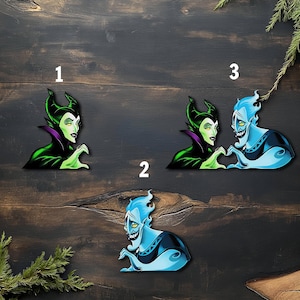 May include: Three cartoon character cutouts. One features a green-skinned woman with black horns and a purple collar. Another shows a blue-skinned man with flames for hair. The third shows the woman and man forming a heart with their hands.