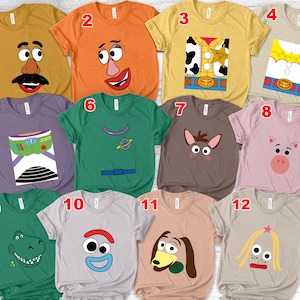 May include: A collection of twelve short-sleeved t-shirts featuring various cartoon character designs. The shirts are in a variety of colors, including mustard yellow, orange, green, and purple. Each shirt has a different character design on the front.