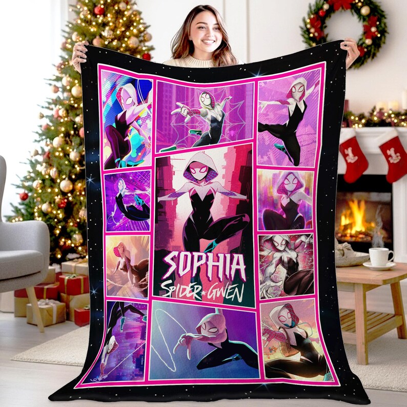 May include: Black fleece blanket featuring a comic book style design of Spider-Gwen. The blanket has a pink border and a grid of images with the name "Sophia Spider Gwen" in the center. The background is black with white stars.
