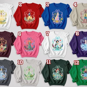 Puede incluir: Una colecci&oacute;n de doce sudaderas en varios colores, cada una con un gr&aacute;fico de princesa diferente dentro de un marco decorativo. Las sudaderas tienen mangas con volantes y est&aacute;n numeradas del 1 al 12.