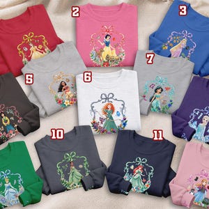 Puede incluir: Una colecci&oacute;n de sudaderas de manga larga en varios colores, cada una con un gr&aacute;fico de princesa diferente dentro de un marco decorativo. Los colores incluyen rojo, rosa, azul, gris, marr&oacute;n, blanco, verde, morado, azul marino y rosa claro. Los dise&ntilde;os muestran personajes de pel&iacute;culas animadas populares.