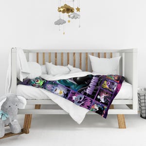 Op de afbeelding: Een kleurrijke babydeken met een collage van stripfiguren in een rasterpatroon. De deken is over een witte wieg met wit beddengoed gedrapeerd. De figuren zijn in tinten groen, paars en zwart.