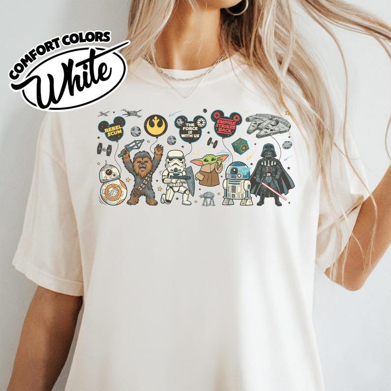 Puede incluir: Camiseta blanca Comfort Colors con un gr&aacute;fico colorido de Star Wars. El dise&ntilde;o incluye ilustraciones de dibujos animados de personajes como Chewbacca, Darth Vader y Baby Yoda, junto con los textos "Rebel Scum" y "The Force is With Us."