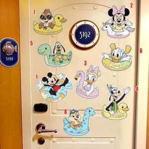 May include: A collection of Disney character stickers, including Mickey Mouse, Minnie Mouse, Donald Duck, and Goofy, each in a pool float. The stickers are colorful and feature the characters in various poses. The door number is 5192.