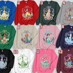 Puede incluir: Una colecci&oacute;n de sudaderas de cuello redondo en varios colores, cada una con un gr&aacute;fico de princesa diferente dentro de un marco floral decorativo. Las sudaderas est&aacute;n disponibles en azul, rojo, verde, gris, negro, blanco, rosa y burdeos.