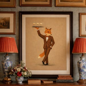 May include: Framed artwork featuring a fox in a brown suit and bow tie, holding a tray with three glasses. The artwork is displayed above a wooden console table with lamps and a floral arrangement. The lamps have orange shades.