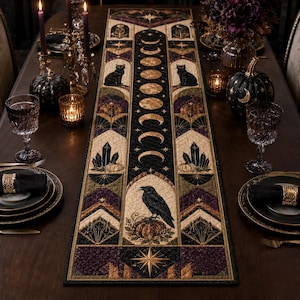 Puede incluir: Un camino de mesa rectangular de tela con un panel central vertical de fases lunares doradas, flanqueado por ilustraciones de gatos negros, cuervos sobre calabazas, cristales y motivos de estrellas geométricas en negro, morado y oro.