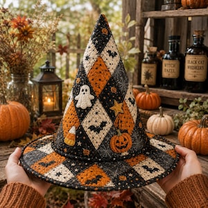 May include: A quilted witch hat featuring a black and orange diamond pattern with appliqued motifs including a white ghost, a jack-o'-lantern, a yellow star, and candy corn. The fabric is decorated with small printed bats, stars, and spiderwebs.