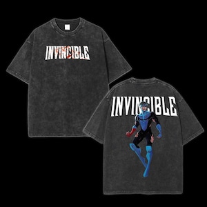 May include: Two black t-shirts with the word "INVINCIBLE" printed on them. One shirt features a graphic of a superhero in a blue and red costume.