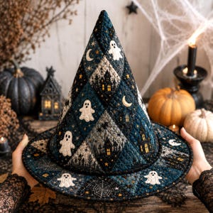 May include: A quilted witch hat featuring a diamond-patterned fabric in shades of dark blue, black, and grey. The design includes embroidered white ghosts, yellow crescent moons, golden stars, spider webs, and silhouettes of haunted houses.