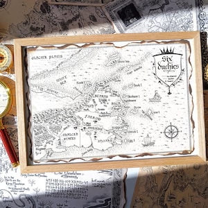 Puede incluir: Un mapa en blanco y negro enmarcado, titulado "Six Duchies". El mapa presenta ilustraciones detalladas de masas terrestres, mares e islas. También se ven una brújula y dos lupas.