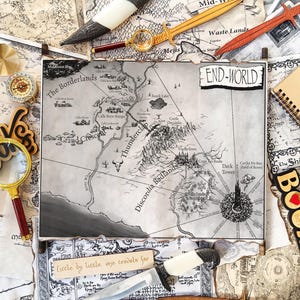 Op de afbeelding: Een geïllustreerde kaart van een fantasiewereld met de tekst "END-WORLD" en "The Borderlands". De kaart is omringd door decoratieve items, waaronder houten zwaarden, een kompas, een vergrootglas en een notitieboek met de tekst "LORD OF THE RINGS".
