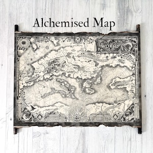 May include: A detailed black and white map labelled "Alchemised Map" with intricate illustrations of landmasses, oceans, and celestial elements. The map is framed with dark wood and has a distressed, aged appearance, mounted on a light wood background.