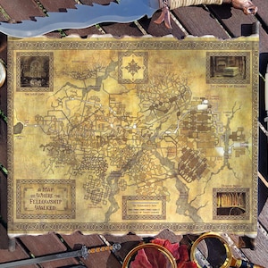 May include: A detailed map with a parchment-like appearance, featuring intricate illustrations and text, is surrounded by a compass, knives, and a sword. The map reads "A Map of Where the Fellowship Walked."