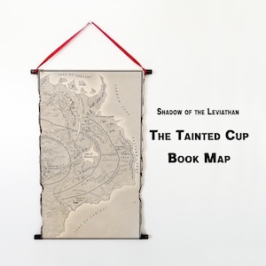 May include: A map print titled "The Tainted Cup Book Map" with the text "Shadow of the Leviathan." The map is in grayscale, with a torn edge design. It hangs from a wooden rod with a red ribbon.