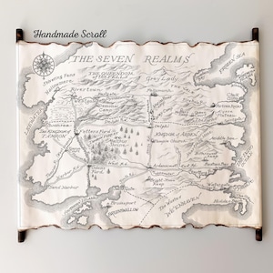 Peut inclure: Un parchemin fait à la main représentant une carte détaillée de « The Seven Realms ». La carte est en noir et blanc, avec des illustrations complexes de caractéristiques géographiques, de villes et de points de repère. Le parchemin est encadré de baguettes en bois foncé.