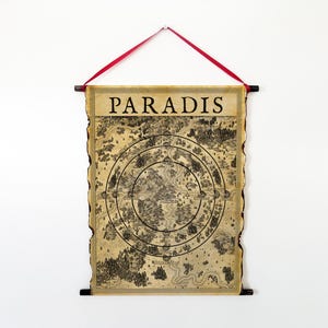 以下が含まれることがあります： 「PARADIS」の文字が上部に書かれた、羊皮紙風の地図。地図は、森林、川、山などの詳細なイラストが描かれた円形のデザインです。赤いリボンと黒い棒で吊り下げられています。