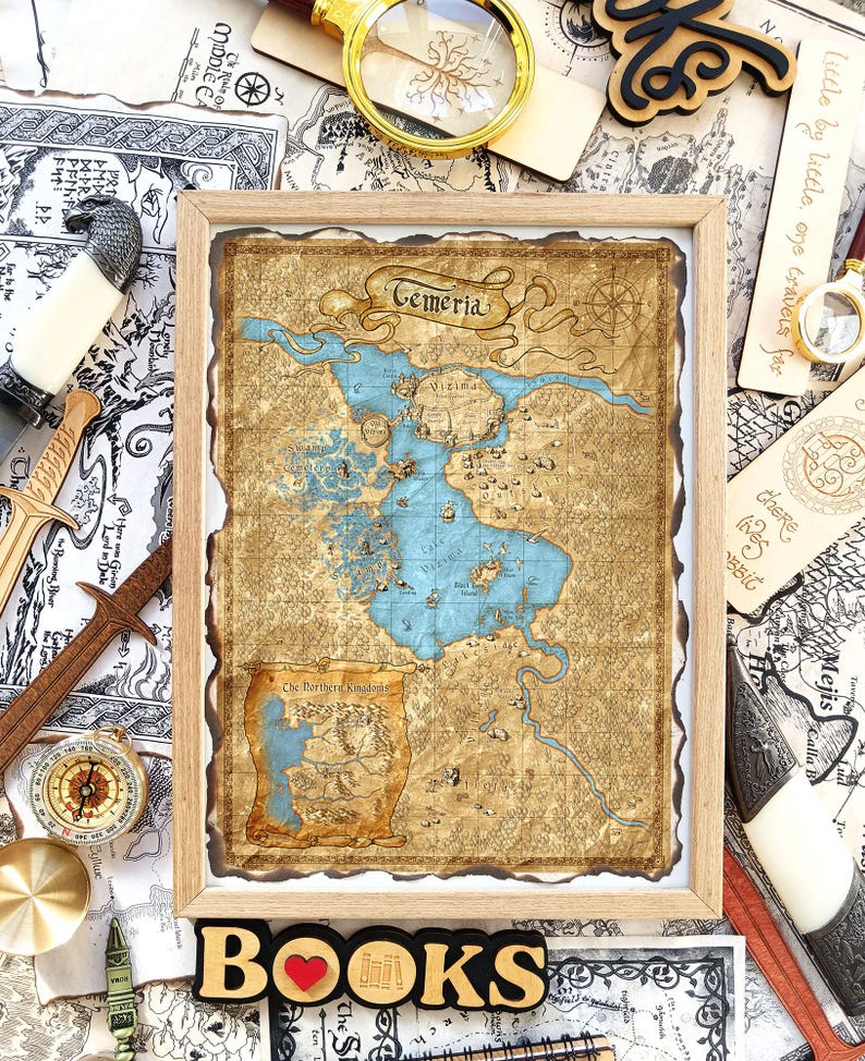 Puede incluir: Un mapa enmarcado de Temeria, con una representaci&oacute;n detallada de una tierra ficticia, con un gran lago azul y territorios circundantes. El mapa est&aacute; en un marco de madera, con la palabra "Temeria" en la parte superior. La palabra "BOOKS" est&aacute; en la parte inferior.