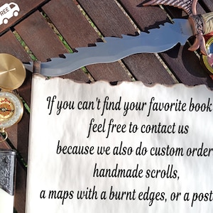 Puede incluir: Un surtido de objetos antiguos, que incluyen una br&uacute;jula, un cuchillo decorativo y una lupa, est&aacute;n dispuestos sobre una superficie de madera. Tambi&eacute;n hay un pergamino con texto. El texto del pergamino dice: "Si no encuentras tu mapa de libros favorito, no dudes en contactarnos..."