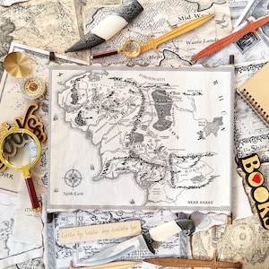 May include: An assortment of fantasy-themed items, including a Middle-earth map, wooden swords, a compass, a magnifying glass, and a notebook with "Lord of the Rings" text. The items are arranged on a background of maps and book pages.