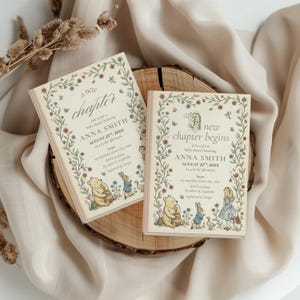 K&ouml;nnte beinhalten: Zwei Babyparty-Einladungen mit floralen R&auml;ndern und dem Text "a new chapter" und "a new chapter begins". Die Einladungen zeigen Illustrationen von Winnie Puuh, Ferkel, Hase und Alice im Wunderland. Die Einladungen liegen auf einer Holzscheibe.