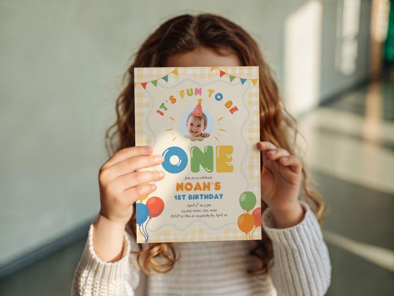 May include: A birthday invitation with the text "It's fun to be ONE" and a photo of a baby wearing a party hat. The invitation has a yellow gingham background and colorful balloons. The invitation is for Noah's 1st birthday.