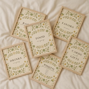 Puede incluir: Seis letreros enmarcados para baby shower con ilustraciones florales y de biberones. Los letreros dicen "BABY", "DRINKS enjoy", "FOOD enjoy", "FAVORS Please take one", "CARDS and GIFTS" y "PHOTO guestbook". Los marcos son de madera clara.