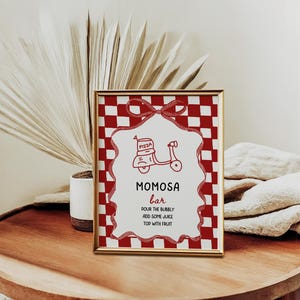 May include: A framed sign with a red and white checkered border and a gold frame. The sign reads "MOMOSA bar" with instructions below. A red scooter graphic is at the top. The sign is on a wooden table.