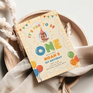 May include: A birthday invitation with the text "It's Fun to Be One" and "Noah's 1st Birthday". The invitation features a photo of a baby wearing a party hat, balloons, and colorful text on a light yellow background.