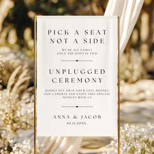 Puede incluir: Un letrero de boda con marco dorado y una pancarta blanca. La pancarta dice "PICK A SEAT NOT A SIDE" y "UNPLUGGED CEREMONY". El letrero también incluye los nombres "ANNA & JACOB" y una fecha.