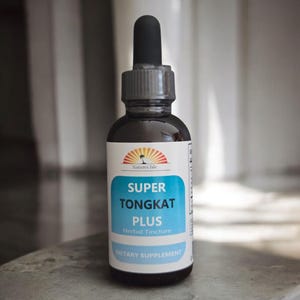 Puede incluir: Una botella de vidrio oscuro de tintura herbal "Super Tongkat Plus" con un cuentagotas negro. La etiqueta presenta la marca "Natures Isle" y un rectángulo turquesa con texto blanco. Es un suplemento dietético.