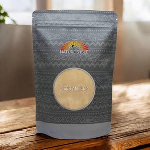 Könnte beinhalten: Ein grauer Beutel mit Stammesmuster und dem Text "NATURE'S ISLE" und "DEER ANTLER". Der Beutel steht auf einer Holzoberfläche. Das Produkt ist wahrscheinlich ein Nahrungsergänzungsmittel oder ein Gesundheitsprodukt.