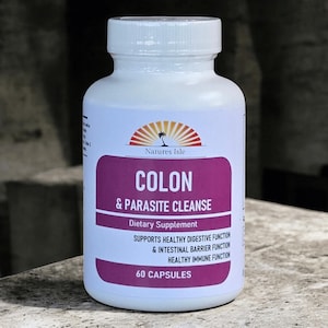 Puede incluir: Una botella blanca de suplemento dietético "Colon & Parasite Cleanse". La etiqueta presenta una pancarta morada con texto blanco y un logotipo de un sol sobre el océano. La botella contiene 60 cápsulas y apoya la función digestiva e inmune saludable.