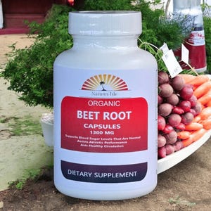 以下が含まれることがあります： 「Natures Isle Organic Beet Root Capsules 1300 MG」の白いボトルの栄養補助食品。赤と白のラベルには、血糖値、運動能力、健康な循環をサポートすることが記載されています。新鮮な農産物の隣にボトルがあります。