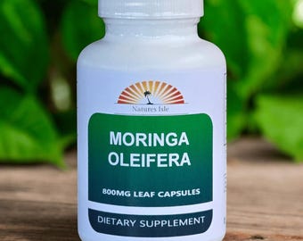 May include: A white bottle of Moringa Oleifera leaf capsules. The label features the text "Moringa Oleifera" in large green letters, along with "800mg Leaf Capsules" and "Dietary Supplement". The bottle has a white cap and a logo of a palm tree.