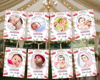 May include: A custom 12-month photo banner with baby photos. Each card has a cherry design, the name "Jasmine", and the month. The banner is strung with clothespins. Text includes "Happy Birthday" and "A year of love, a lifetime to go."