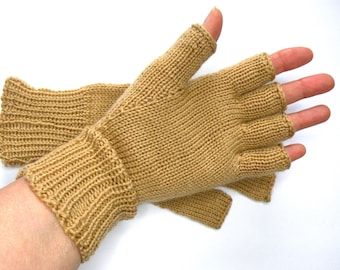 May include: A pair of tan fingerless gloves featuring a ribbed knit cuff and a smooth stockinette stitch pattern on the hand. The gloves are designed with open fingertips and an open thumb, showcasing a consistent light brown yarn construction.