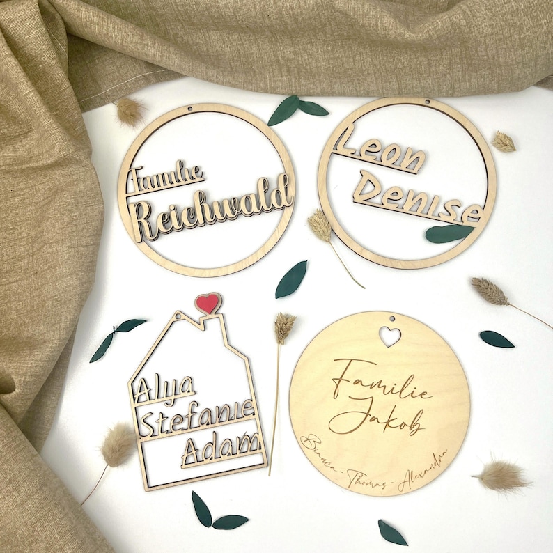 Beispiele personalisierter Holzschilder für Türkränze – ideal für Familien, Paare oder Geschenke, handgefertigt von CraftyVonCristina.