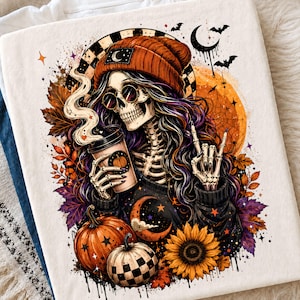 May include: A white t-shirt featuring a graphic of a skeleton wearing an orange beanie and round sunglasses, holding a steaming coffee cup. The design includes autumn leaves, pumpkins, a sunflower, a crescent moon, and bats in orange and purple tones.